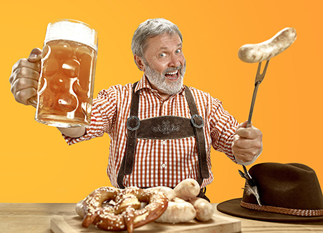 Delighted senior man with beer dressed in traditional Austrian or Bavarian costume holding mug of beer at pub or studio. The celebration, oktoberfest, festival, drinking concept. Flyer with copyspace.